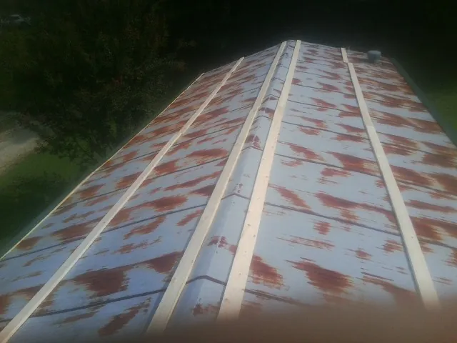 Rusted metal roof panels with new wood purlins before replacement — Storm Damage Roof Repair in Sandwich by Roofing Brothers
