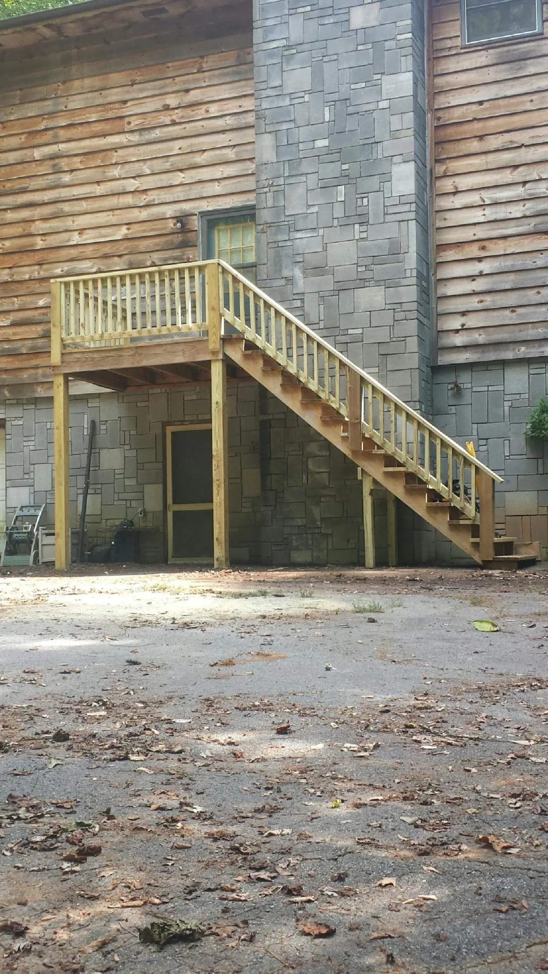 New pressure treated deck and stair landing on a log home in Sandwich