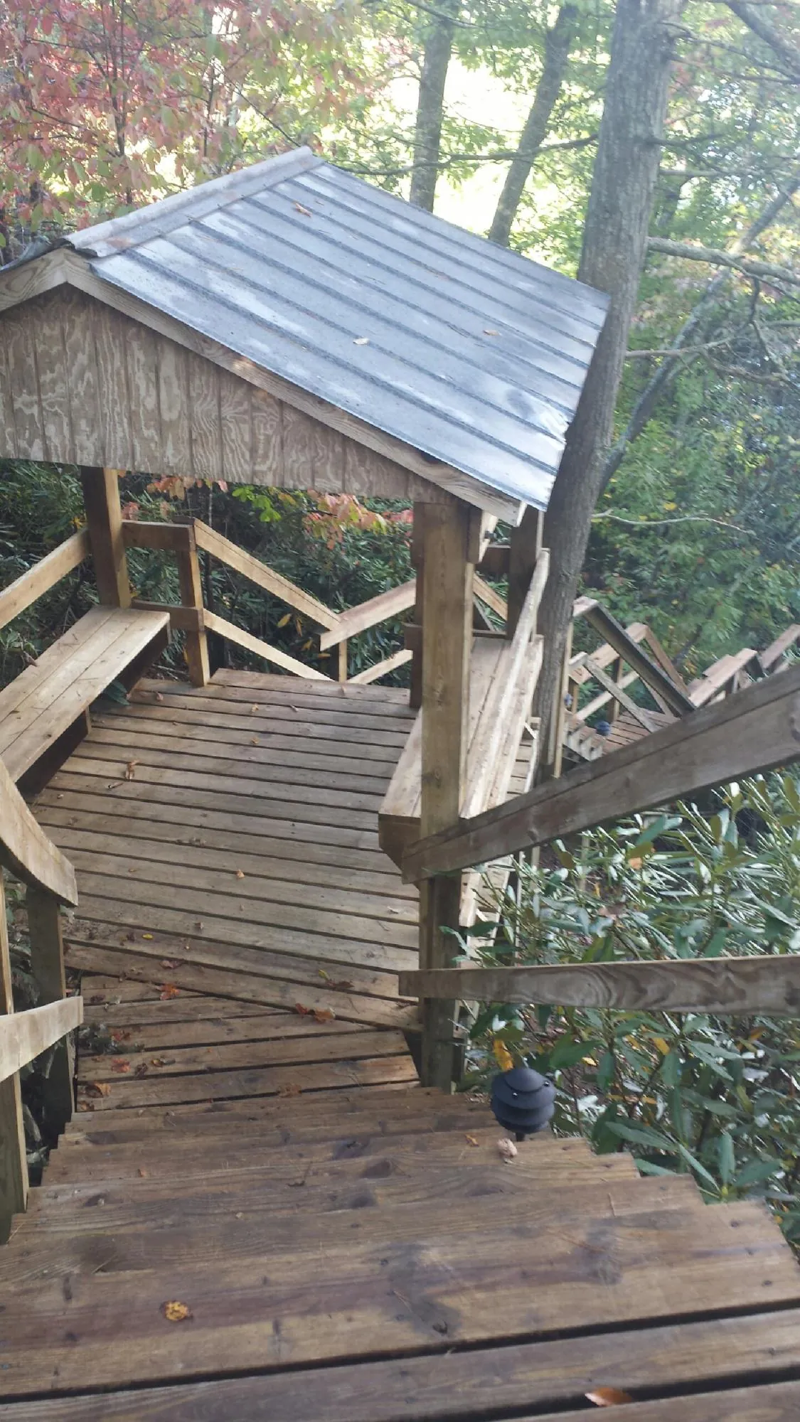 Metal roofed shelter over wooden steps on a wooded walkway — Skylight Repair & Installation work by our crew in Sandwich